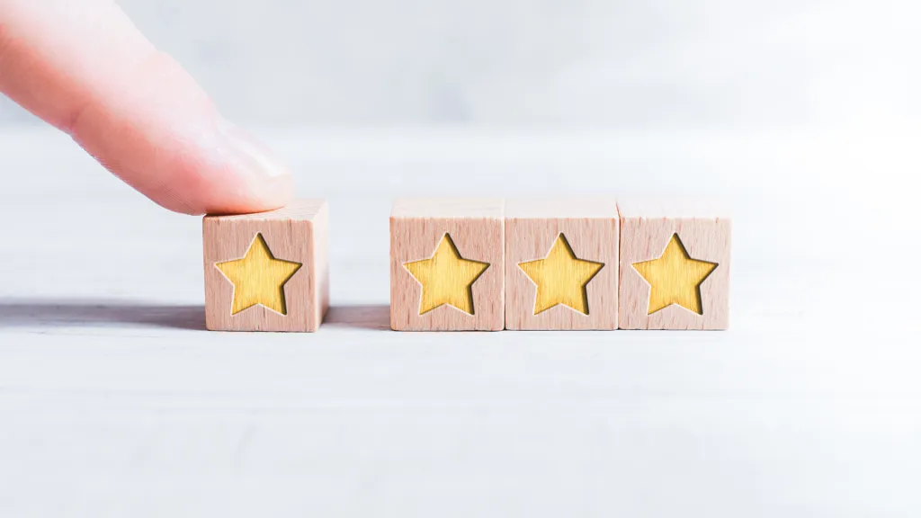 a finger touching a wooden block with stars